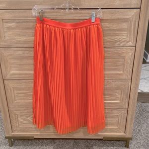 A New Day pleated vibrant coral skirt. Elastic waistband. Midi length.